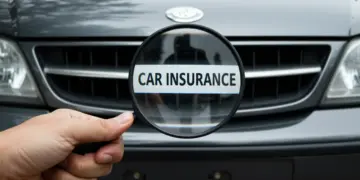 Mão segurando lupa sobre a grade frontal de um carro, simbolizando a análise de seguro para veículos mais antigos.