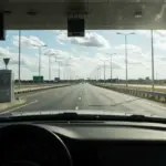 Carro passando por uma praça de pedágio com tag de pagamento eletrônico, simbolizando economia e praticidade em viagens.