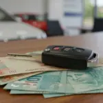 Chave de carro sobre notas de real, simbolizando refinanciamento rápido e acesso a capital.