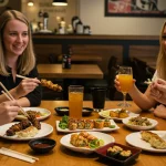 Friends enjoying Japanese izakaya-style food in a US restaurant.